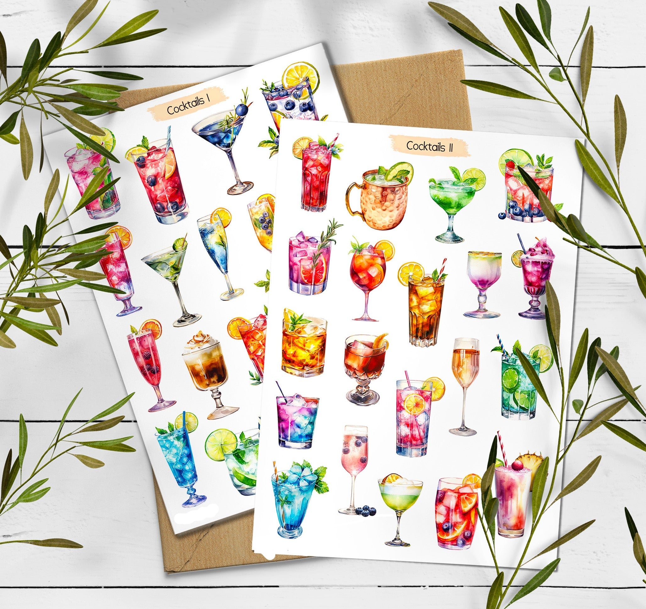 Two sheets of cocktail-themed stickers on a wooden surface with green leaves.